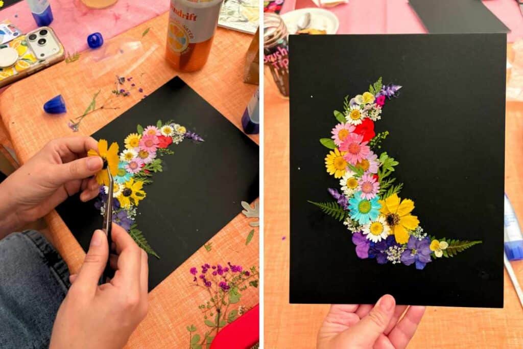 A two-photo collage showing a crescent-shaped pressed flower art arrangement in progress on a black mat board using tweezers, beside the finished piece held up against a colorful craft night background.