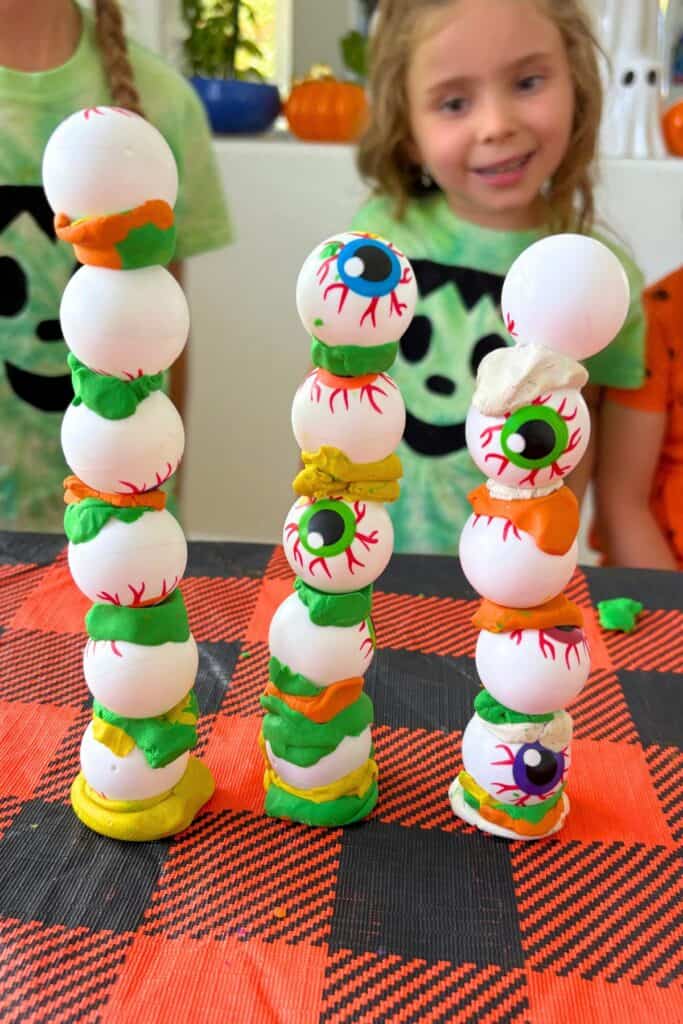 Three different eyeball towers from this Halloween STEM activity, each built to a different height with a different clay color pattern.