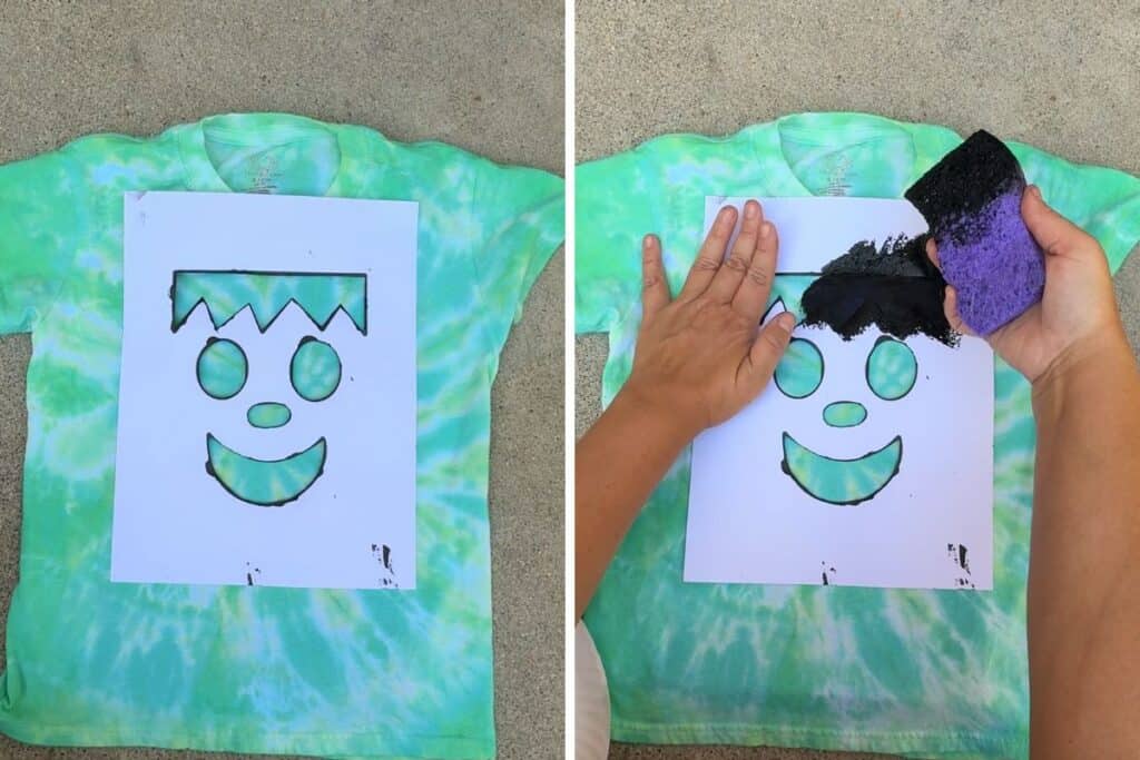 Placing the Frankenstein stencil on the dyed shirt and sponging on black paint over the cutout hair, eyes, nose, and mouth shapes for Frankenstein Halloween tie-dye shirts.