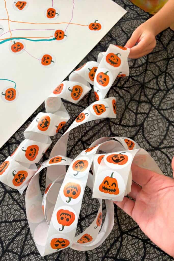 Rolls of orange jack-o-lantern stickers used for a Halloween pumpkin matching activity.